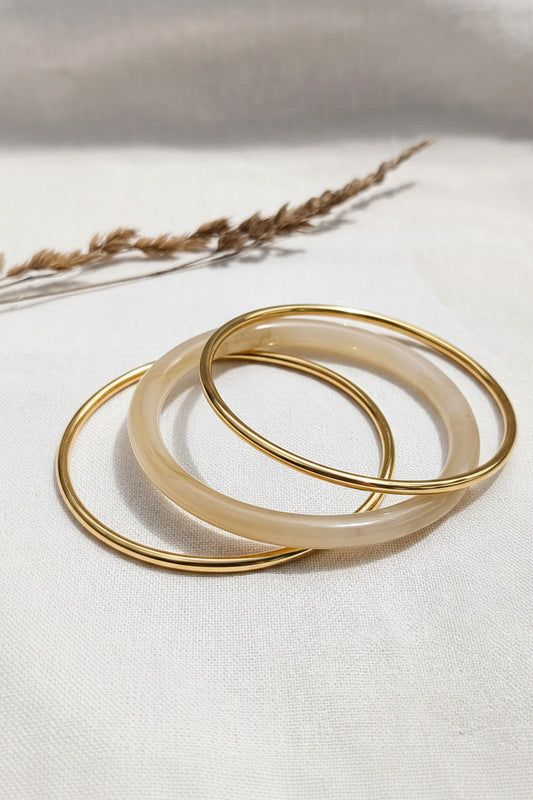 Lot de 3 bracelets joncs dorés et un beige translucide