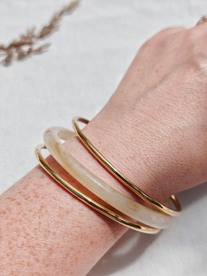 Lot de 3 bracelets joncs dorés et un beige translucide